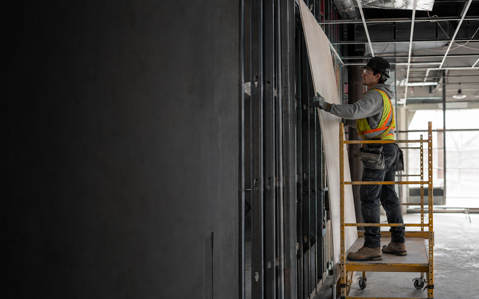 Drywall, Acoustic and Lathing Applicator working safely in a representative workplace