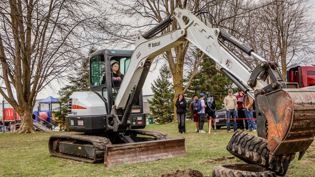 Student operating an excavator during a supervised demonstration